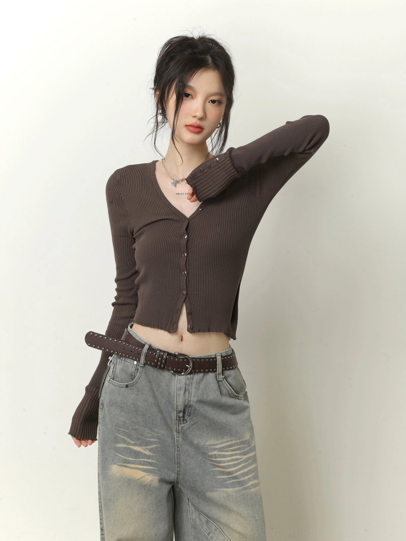Dark brown cropped ribbed knit cardigan with V-neck, button front, extended cuffs, and faded gray wide-leg jeans