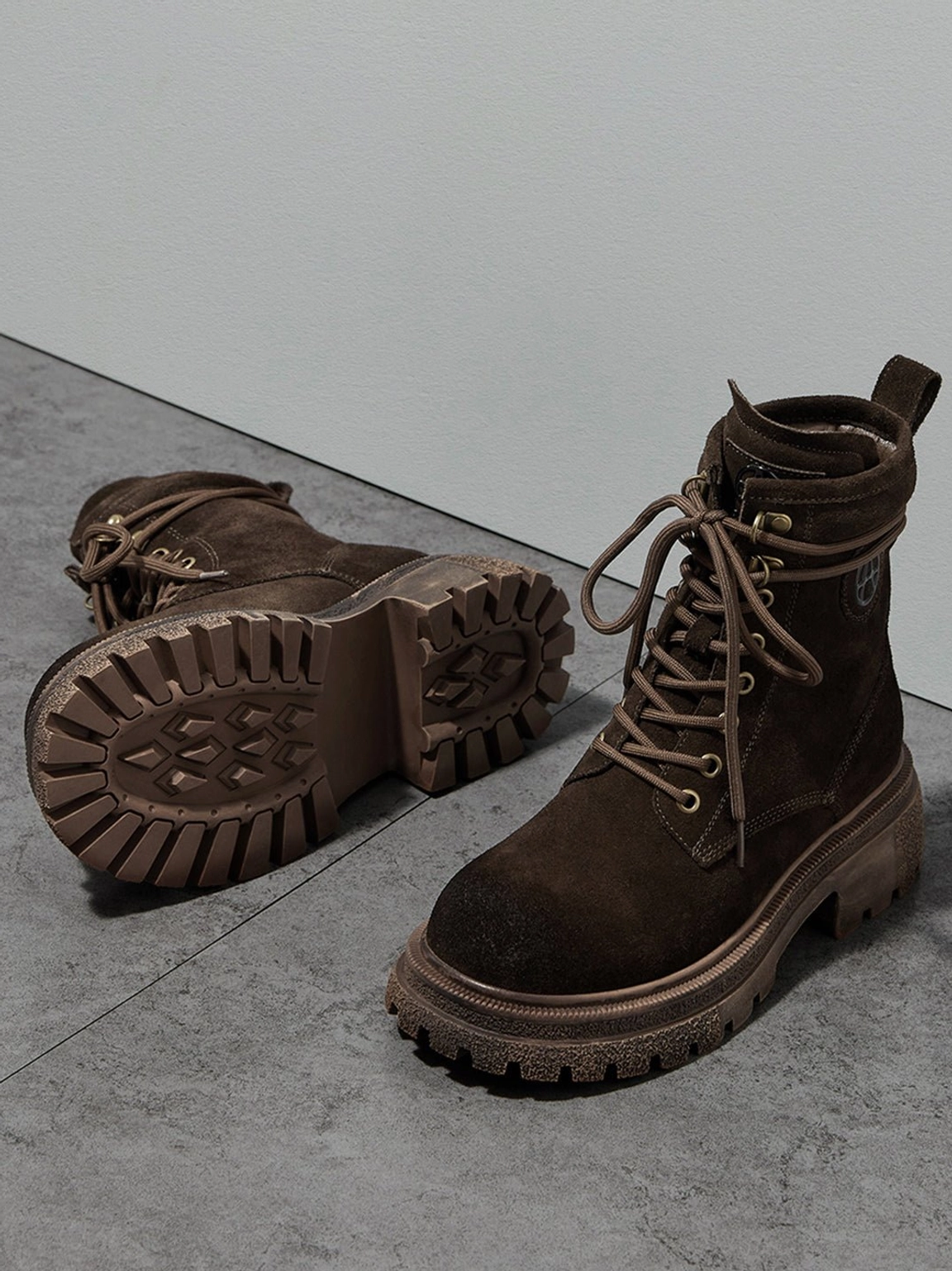 Dark brown distressed combat boots worn on model outdoor setting showing real-world streetwear application durability