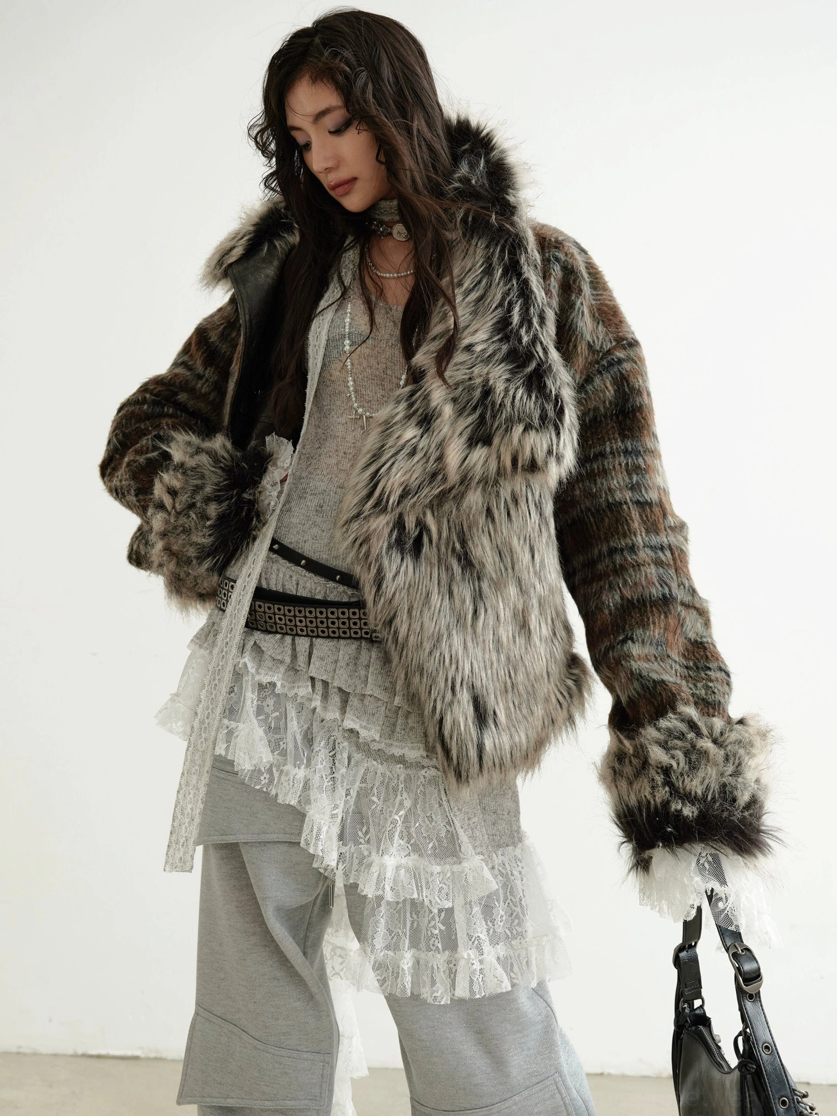 Vintage-inspired cropped faux fur jacket styled with a layered lace top and wide-leg trousers in a winter streetwear outfit
