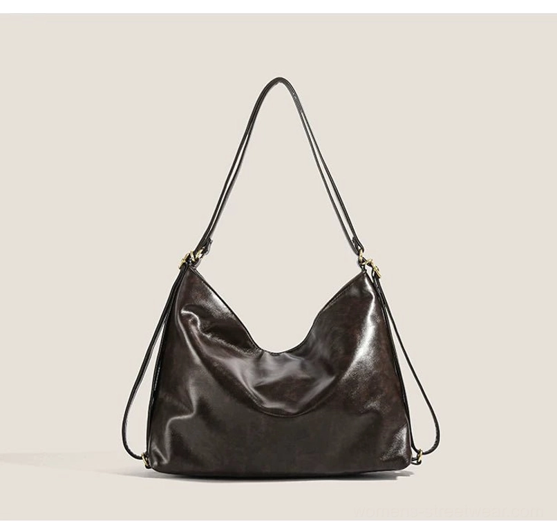Minimal dark brown hobo shoulder bag shown straight on with smooth leather-look exterior, long adjustable strap, and understated streetwear design