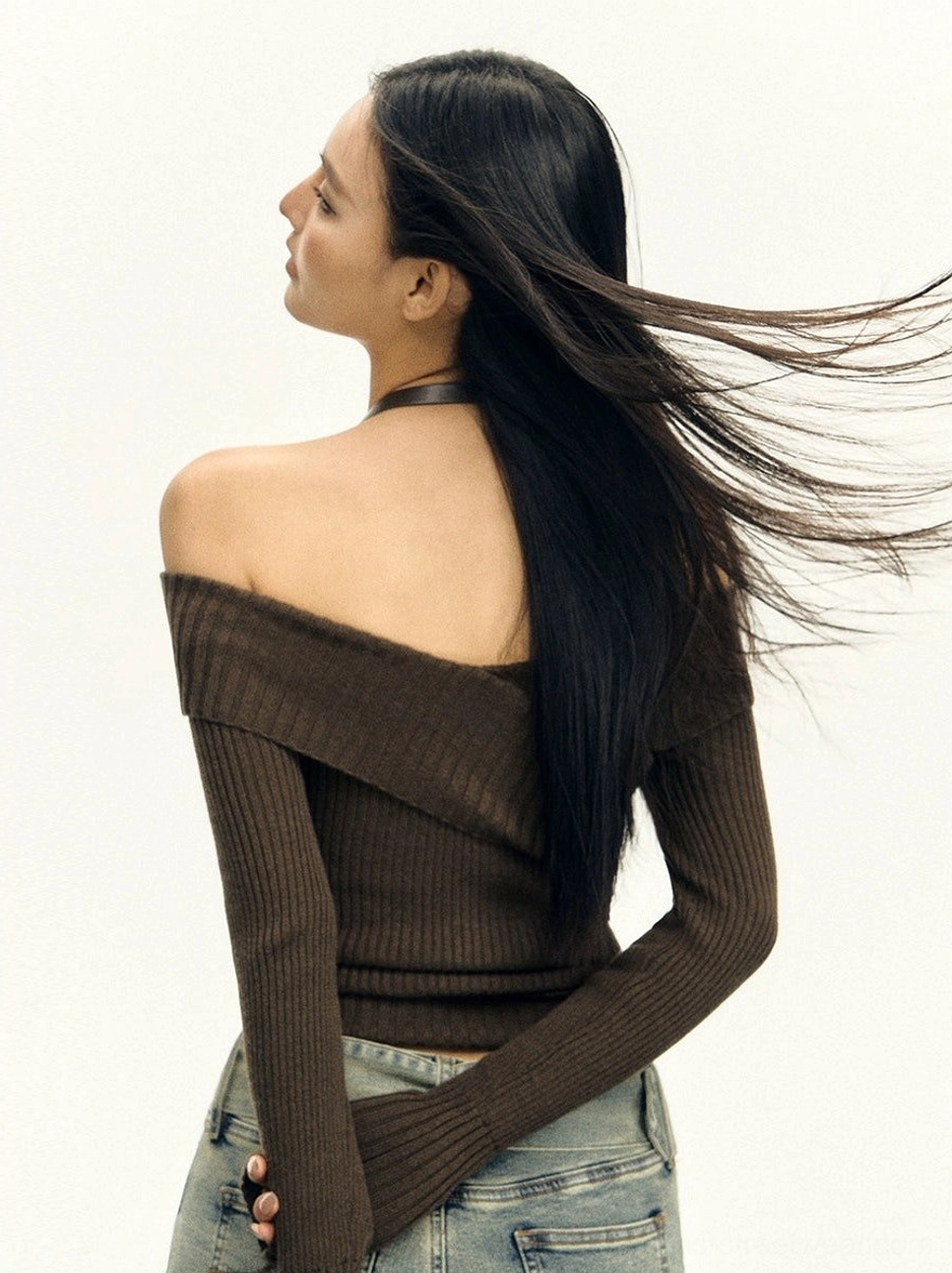 Back three-quarter view of dark brown off-shoulder ribbed knit top with exposed shoulders and halter choker strap
