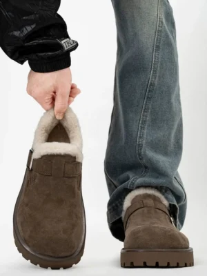 Dark brown shearling-lined winter clogs shown from the front with a wide adjustable buckle strap, cozy fleece lining, and rugged platform lug sole