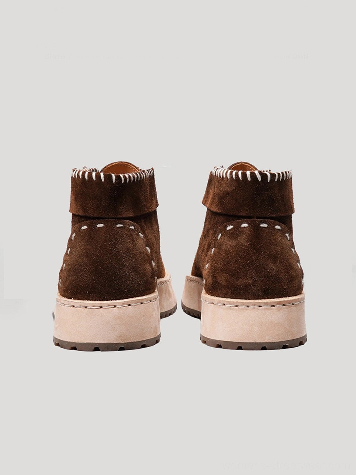 Rear view of dark brown split-toe leather chukka boots showing ankle collar stitching and thick off-white outsole