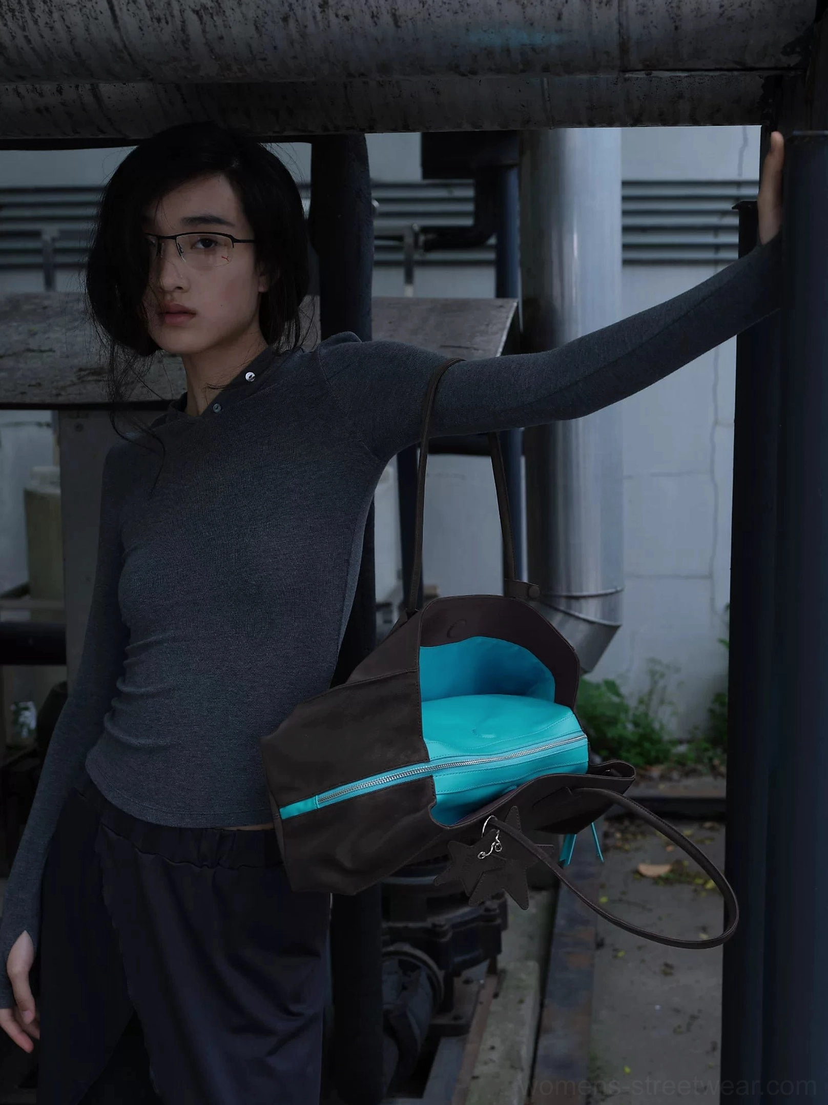 Dark brown structured commuter tote bag with turquoise zipper trim adjustable shoulder strap and matte PU finish