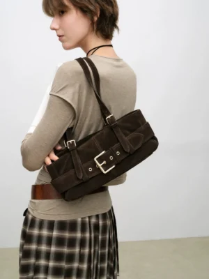 Dark brown suede-style buckle baguette shoulder bag worn by a woman in a casual Seoul-inspired streetwear outfit