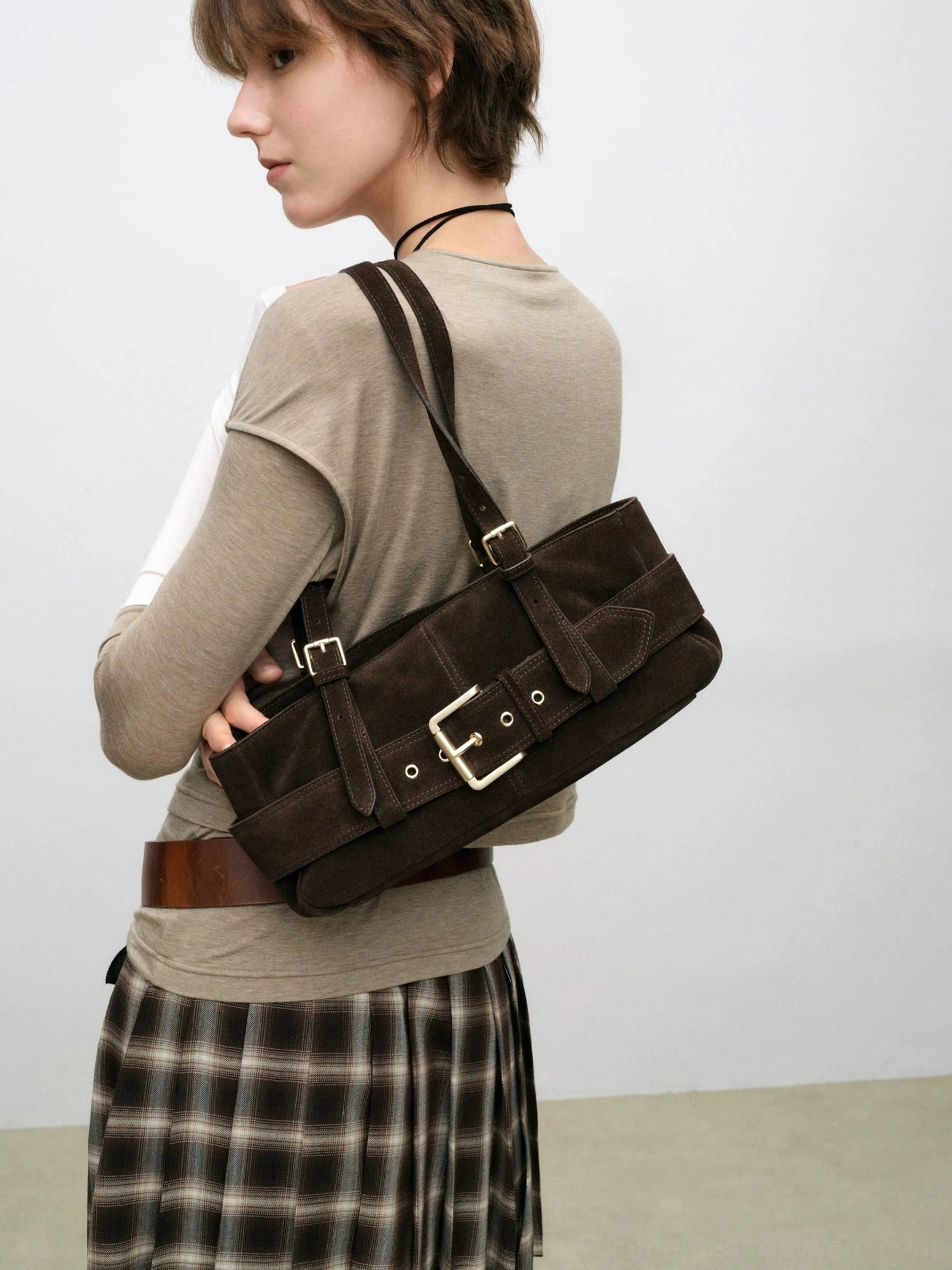 Dark brown suede-style buckle baguette shoulder bag worn by a woman in a casual Seoul-inspired streetwear outfit