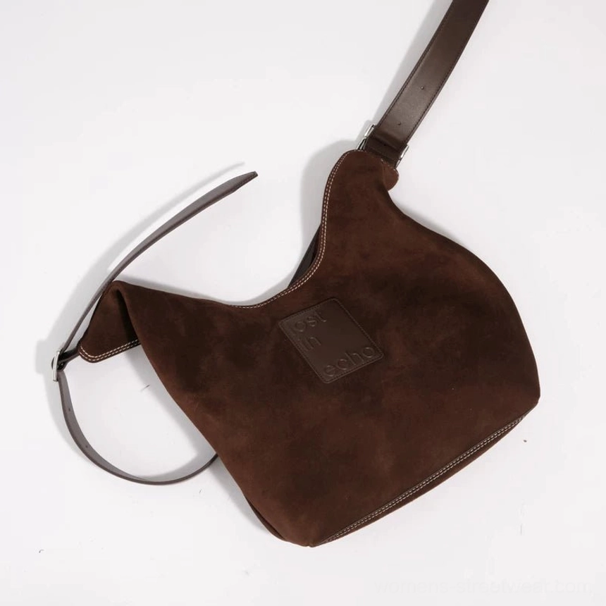 Dark brown suede and canvas commuter tote bag shown from above with embossed leather detail and adjustable two-tone shoulder strap
