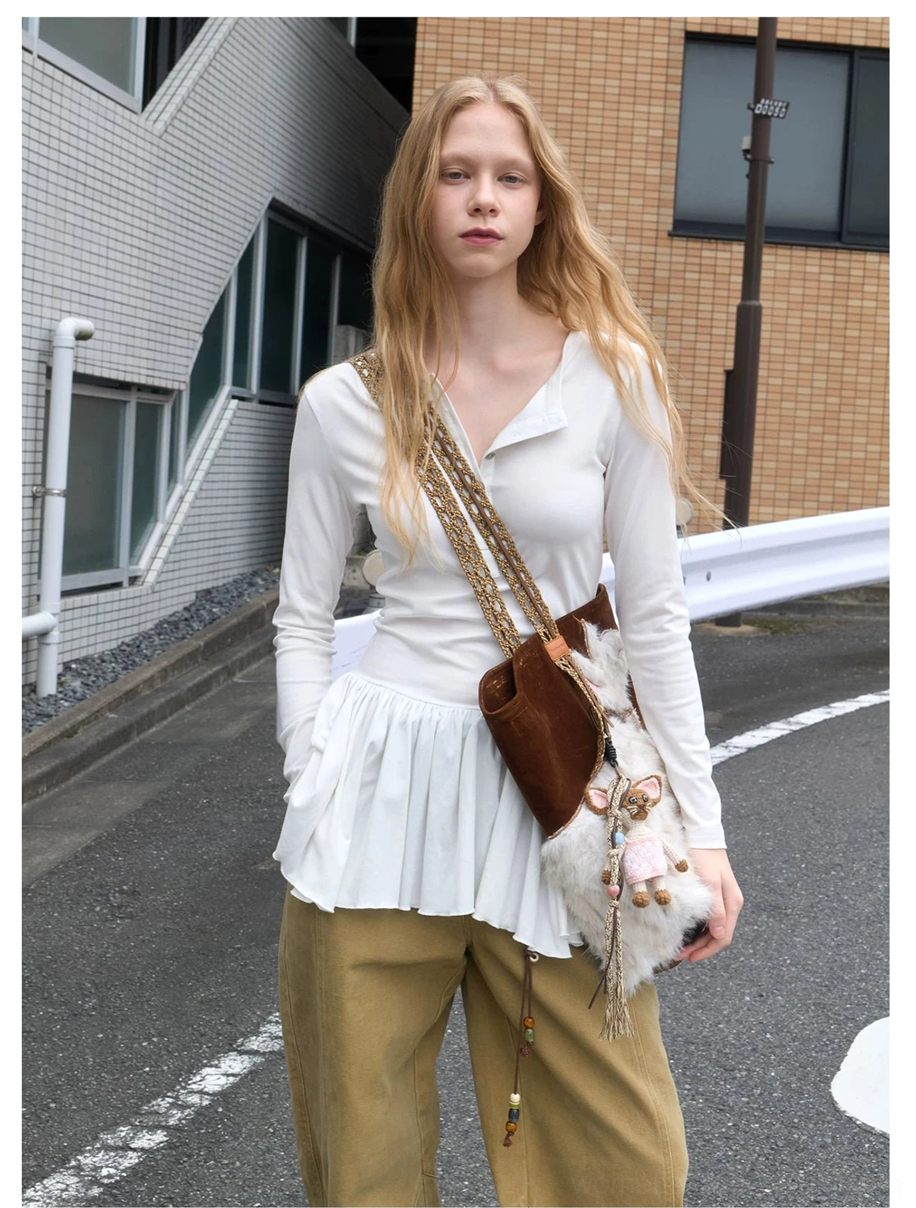 Dark brown velvet cat tote bag with spotted cat applique and chain shoulder strap styled with a white top and khaki trousers