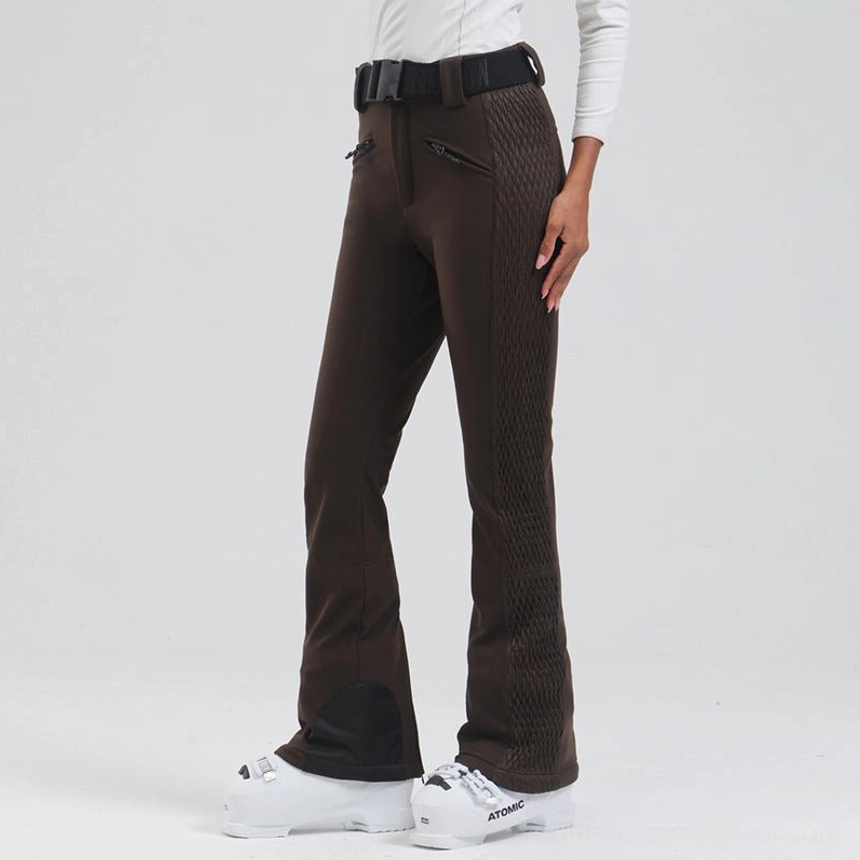 Low angle side view of dark brown women's streetwear ski pants with textured quilted panels, flared legs, and black heel patches