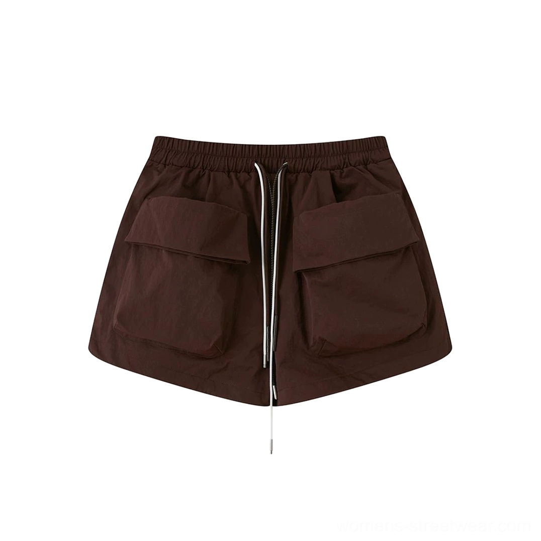 Dark brown women’s utility cargo shorts flat lay with dual-tone drawcord waistband and two oversized flap pockets