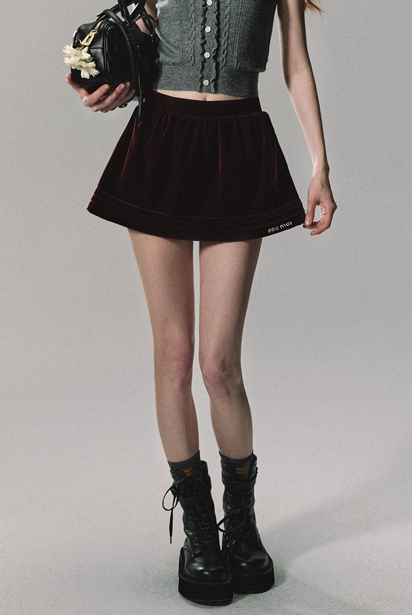 Dark burgundy velvet A-line mini skirt with pleated flare and cropped grey knit top in a Korean streetwear look