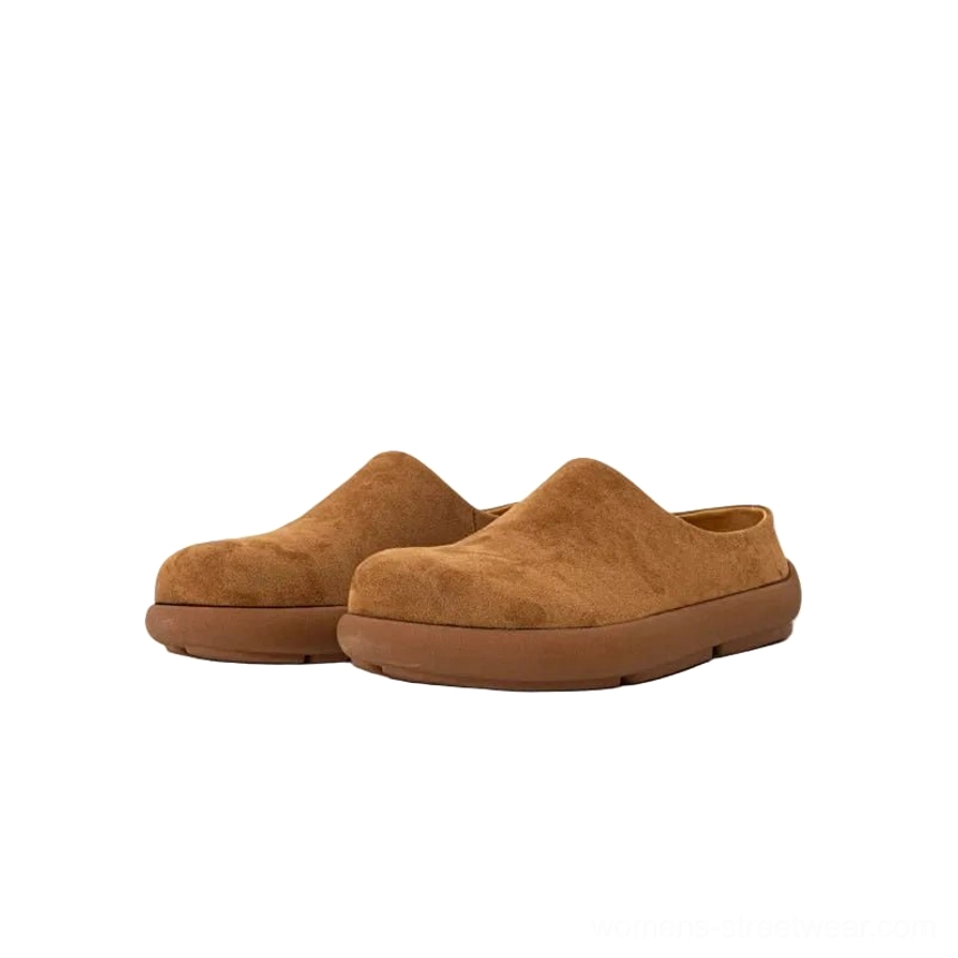 Dark caramel brown suede mule clogs shown as a pair, featuring a classic backless slip-on silhouette, rounded toe, and thick coordinated rubber outsole