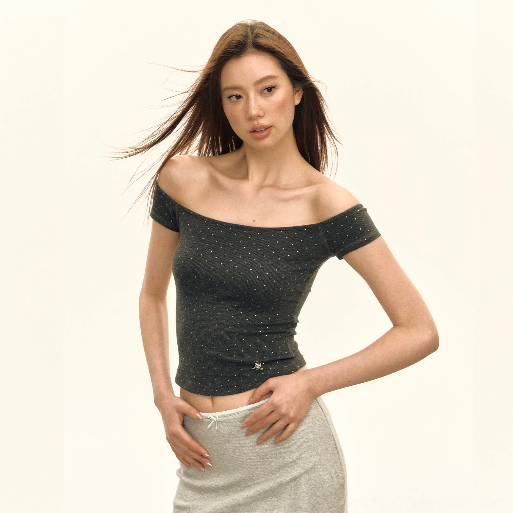 Dark charcoal gray crystal dot embellished off shoulder ribbed cropped top styled with a light gray low rise skirt
