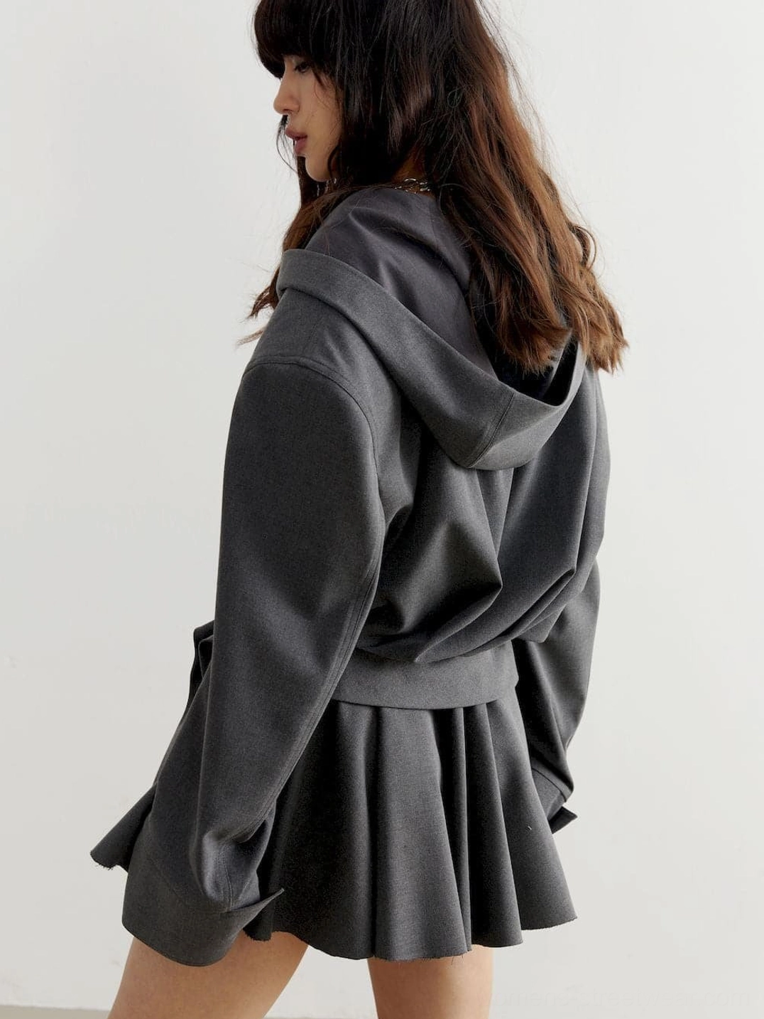 Dark charcoal gray cropped hoodie with oversized upper body, dropped shoulders, long sleeves, and contemporary Korean fashion fit