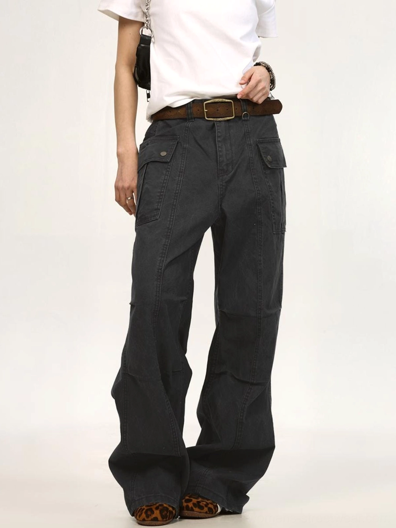 Dark charcoal gray relaxed wide-leg canvas cargo pants shown from the front with side flap pockets, utility details, and modern streetwear styling