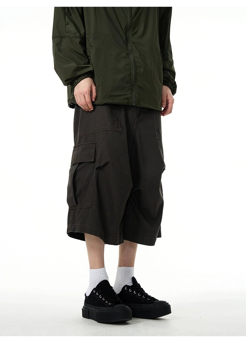 Back view of dark charcoal oversized cargo pants with wide legs and functional side pockets