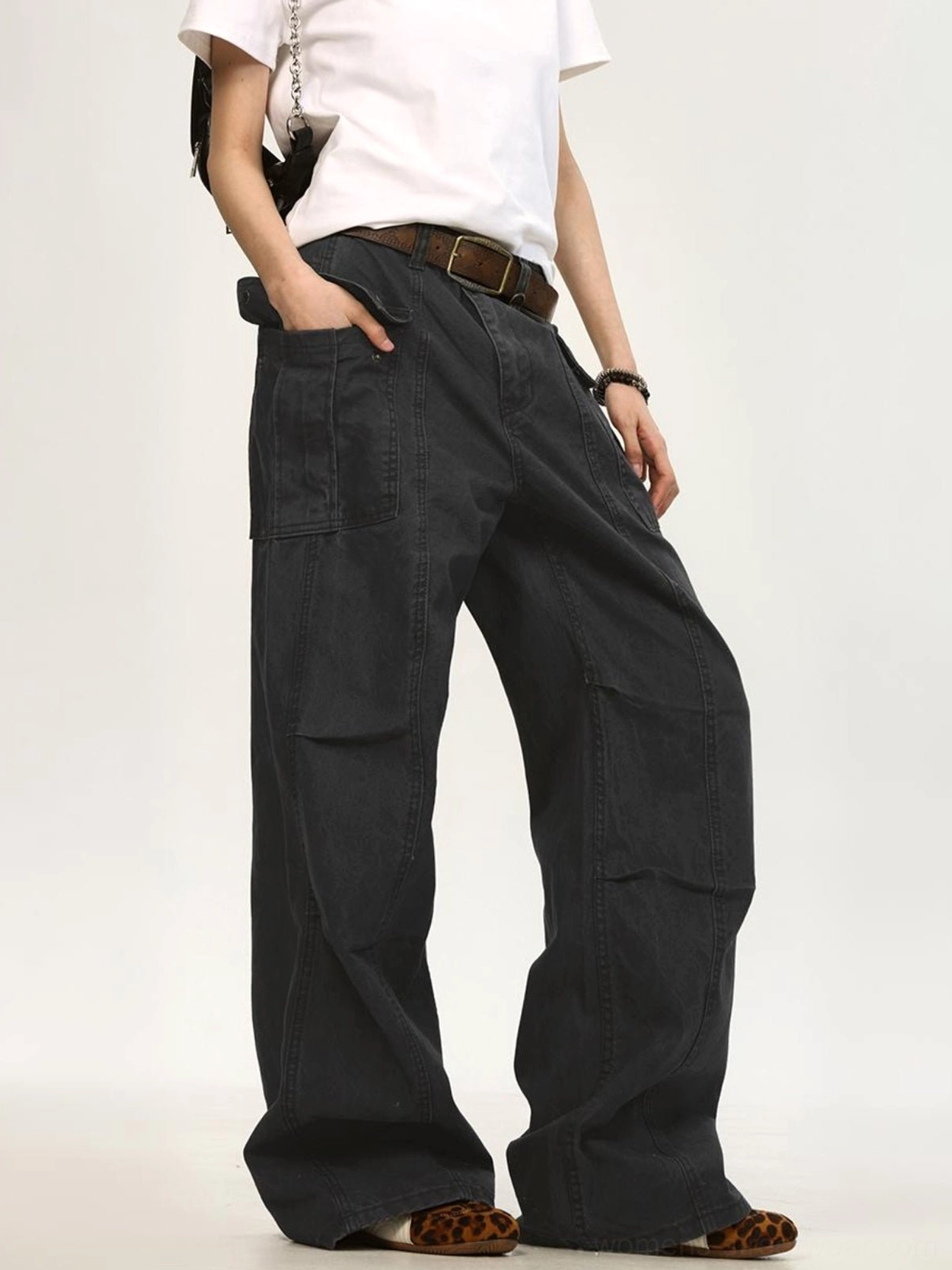 Dark charcoal black unisex canvas cargo pants shown from a three-quarter side view with a loose wide-leg silhouette, practical side pockets, and urban streetwear appeal