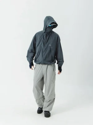 Full-body front side view of charcoal gray UV windbreaker with concealed hood and face cover paired with cargo pants