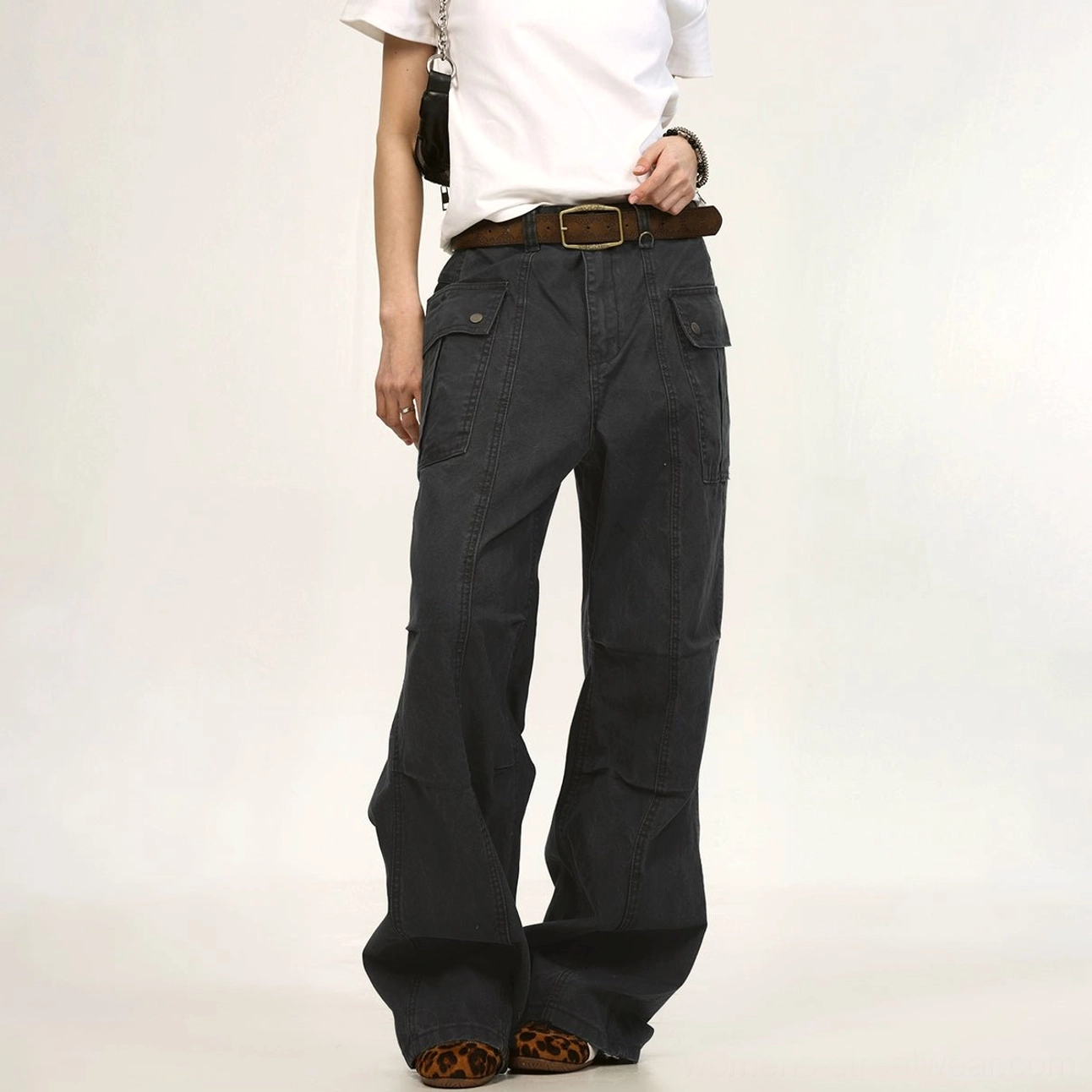 Dark charcoal gray wide-leg utility cargo pants shown from the front with flap side pockets, structured seams, relaxed fit, and contemporary unisex streetwear styling
