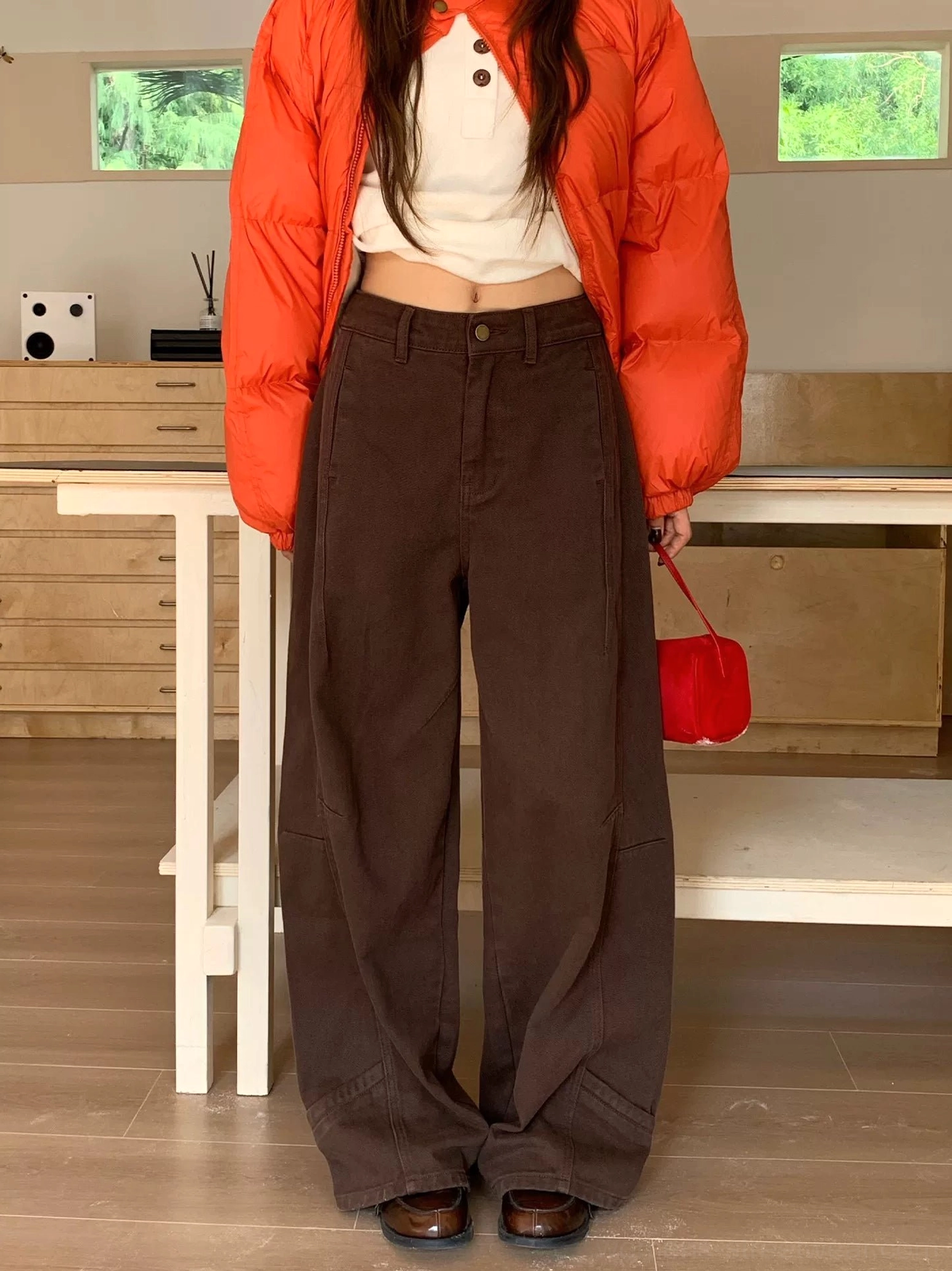 Dark coffee wide-leg jeans with vertical panel seams and relaxed oversized proportions styled for everyday urban fashion