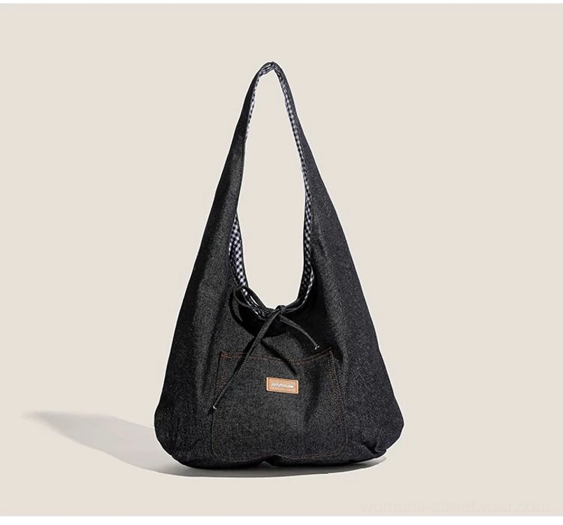 Dark denim drawstring sling tote bag with black and white gingham lining, front pocket, and shoulder strap