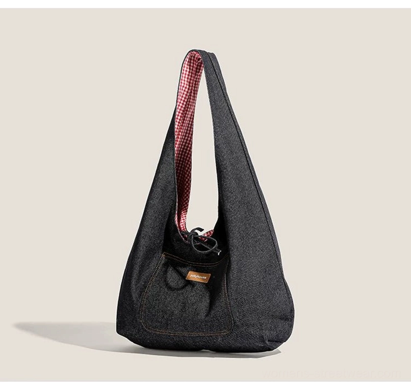 Dark denim hobo sling tote side view showing red plaid gingham lining, drawstring closure, and front utility pocket