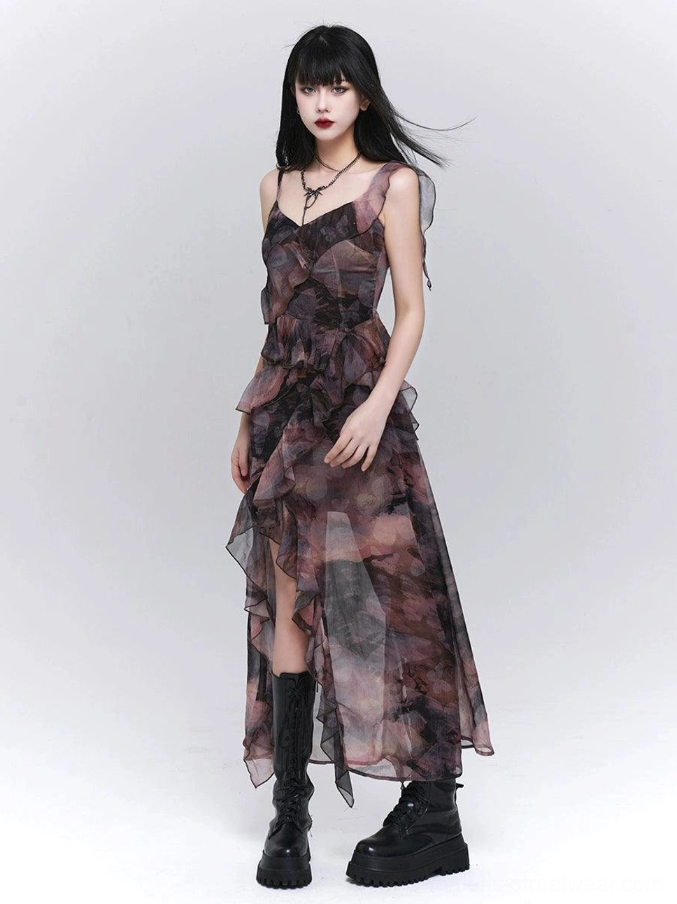Front view of a dark floral asymmetrical maxi dress with ruched waist, layered ruffle skirt, sheer fabric, and dramatic high side slit