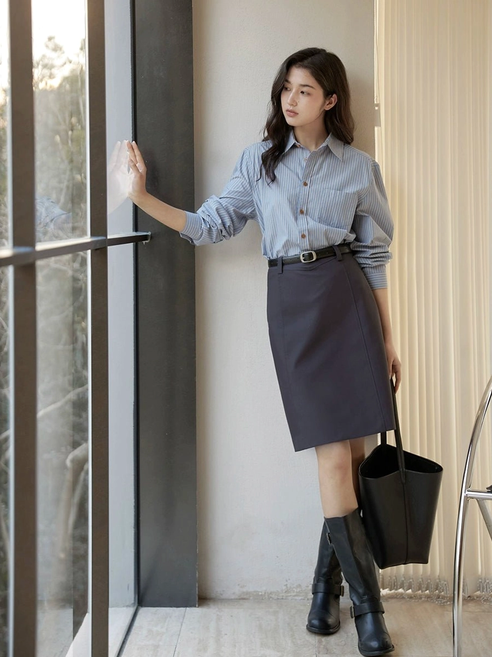 Dark gray asymmetrical belted tailored skirt shown in a three-quarter side view with a knee-length straight silhouette and minimalist Korean streetwear styling