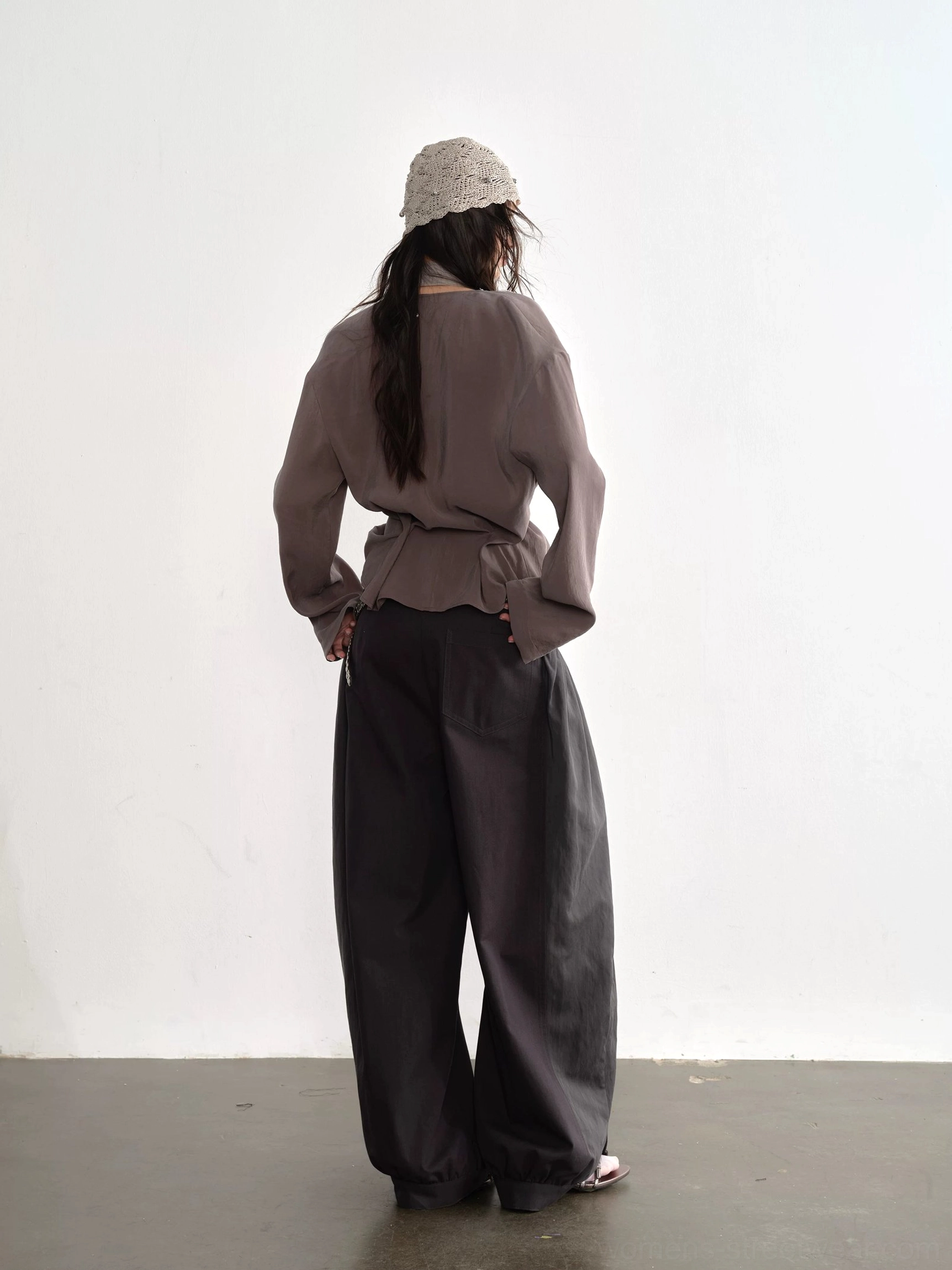 Dark gray balloon tie waist streetwear pants back view paired with cropped taupe top