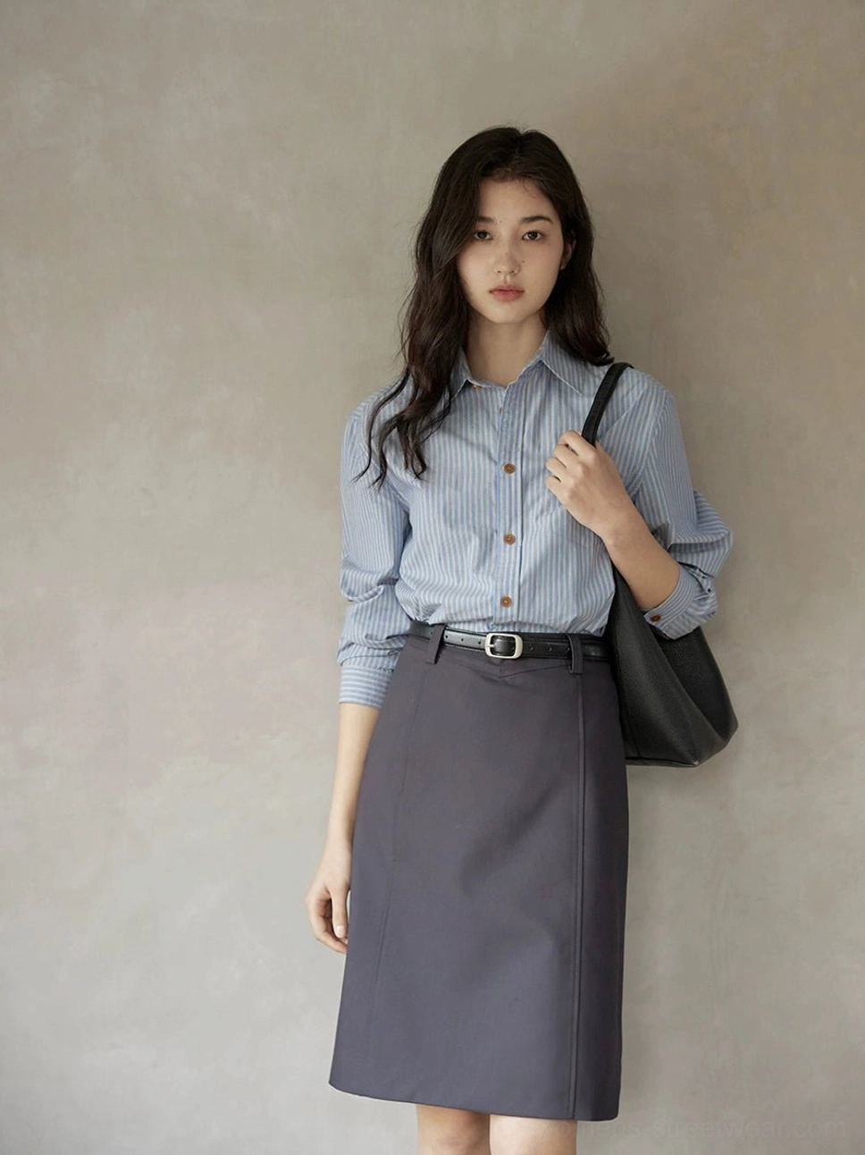 Dark gray belted pencil skirt styled with a black waist belt and shoulder tote in a minimalist urban outfit for Korean fashion and smart casual wear