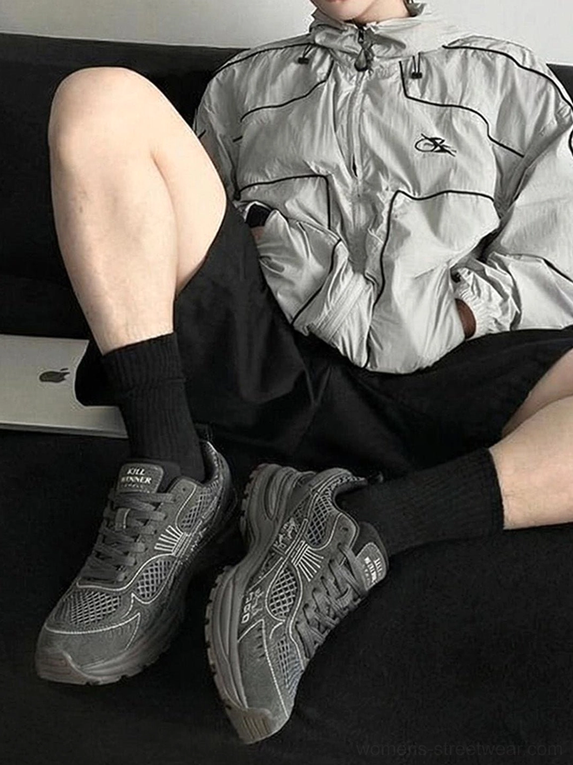 Dark gray chunky mesh runner sneakers worn with black shorts and crew socks in a casual streetwear outfit