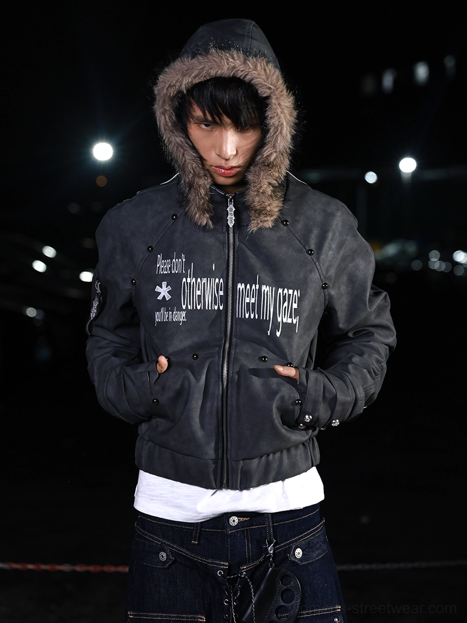 Front medium view of a dark gray faux leather cropped jacket with faux fur hood trim and adjustable streetwear cuffs