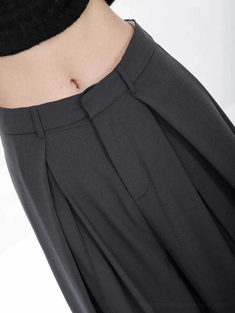Dark gray full-length streetwear trousers with high-rise waist, deep pleats, and fluid wide-leg volume