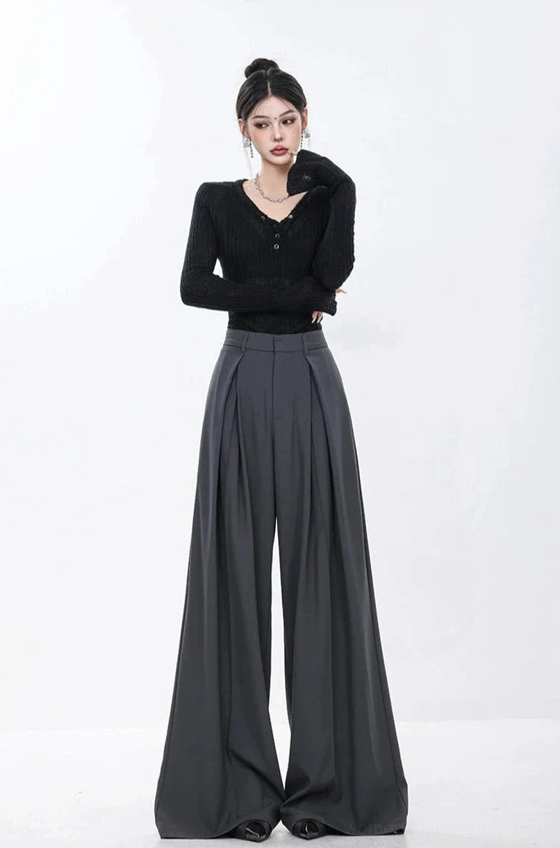 Dark gray high-waisted pleated wide-leg pants with a slim black knit top in a minimalist streetwear outfit