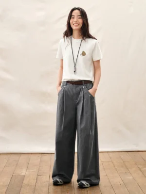 Dark gray high waisted pleated wide leg streetwear trousers styled with a white t shirt and leather belt