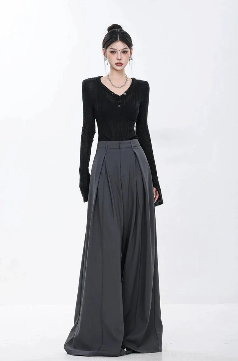 Front view of dark gray high-waisted wide-leg trousers with vertical pleats and tailored streetwear styling