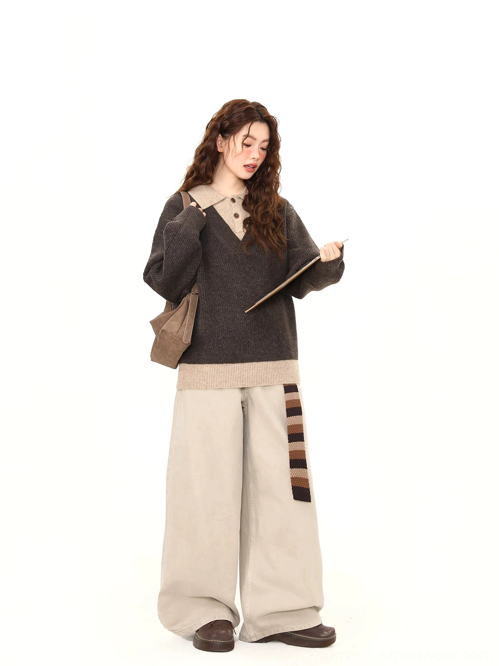 Side view of dark gray contrast collar knit sweater styled with beige wide-leg trousers and brown shoulder bag
