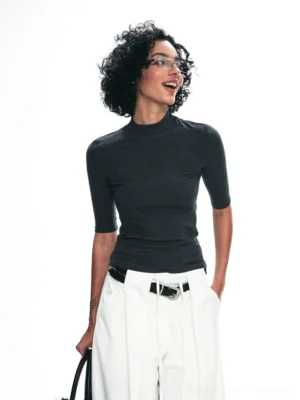 Back three-quarter view of dark gray fitted mock neck half-sleeve streetwear top with white wide-leg pants