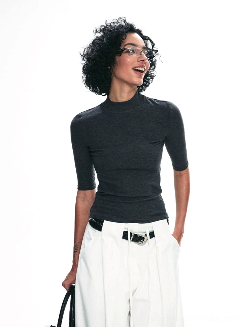 Back three-quarter view of dark gray fitted mock neck half-sleeve streetwear top with white wide-leg pants
