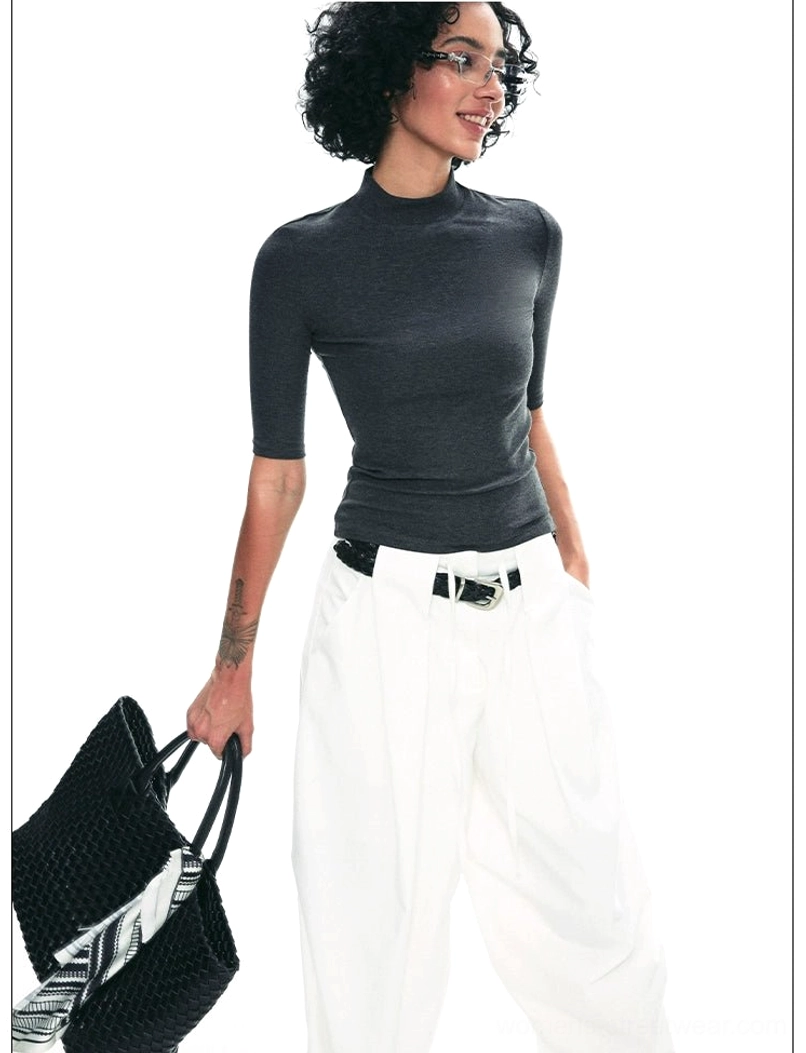 Dark gray mock neck half-sleeve streetwear top styled with white wide-leg pants and woven tote bag