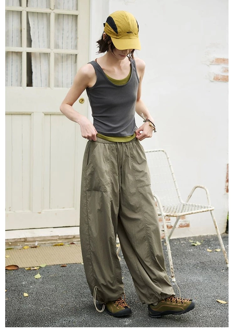 Back view of dark gray and olive green layered fitted tank top styled with cargo wide leg pants