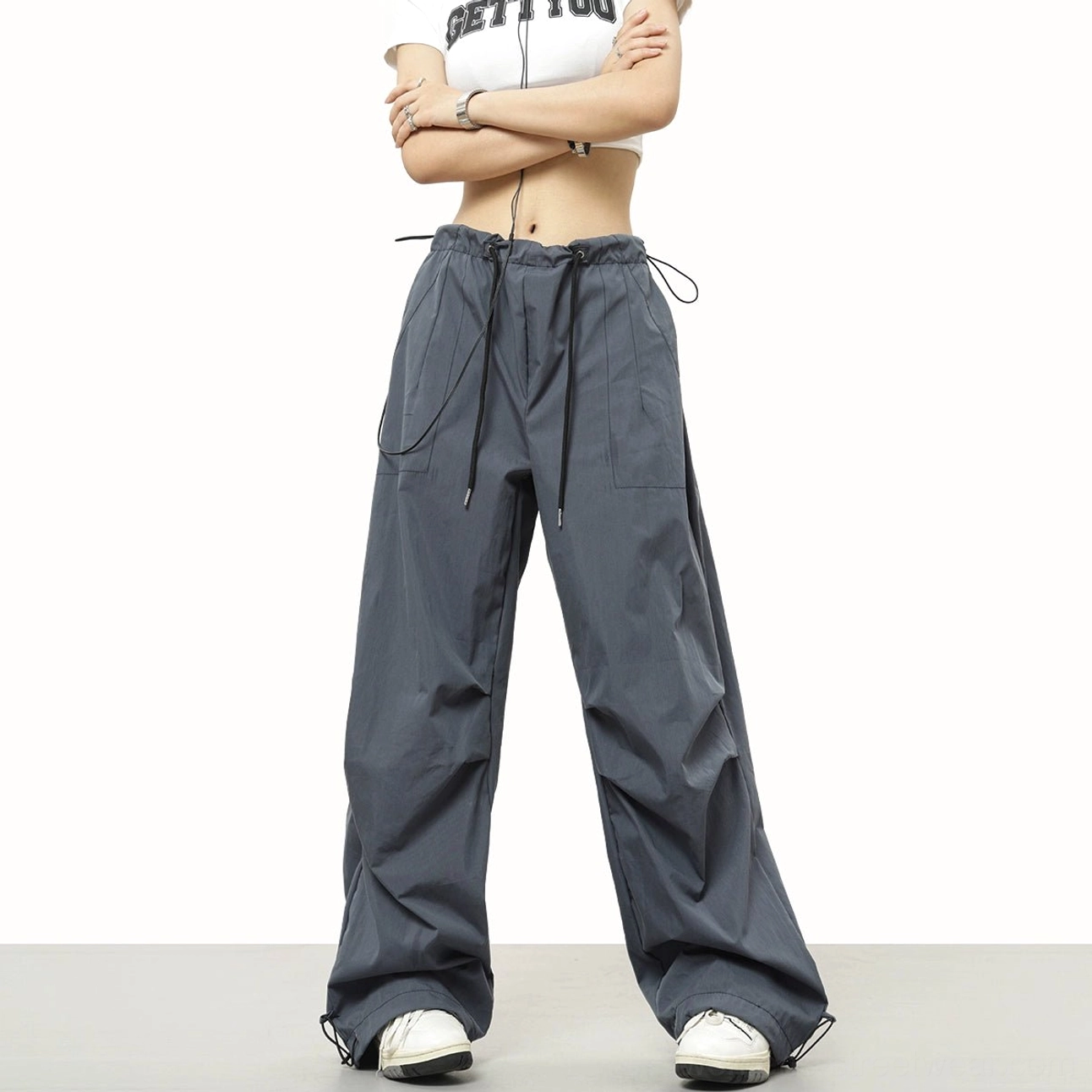 Dark gray parachute wide-leg pants with side utility pockets, adjustable ankle cuffs, and a relaxed Korean streetwear silhouette
