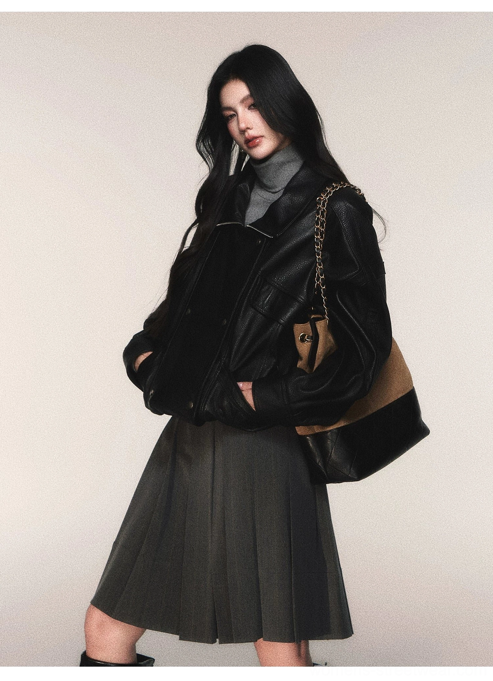Dark gray pinstripe pleated midi skirt styled with black leather jacket shoulder bag and urban preppy streetwear layers