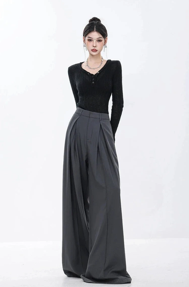 Three-quarter back-side view of dark gray pleated wide-leg trousers with a smooth tailored finish