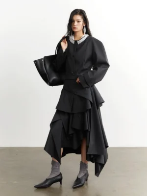 Dark gray silver halo pleated swing shirt jacket styled with an asymmetric ruffled midi skirt in a minimalist studio
