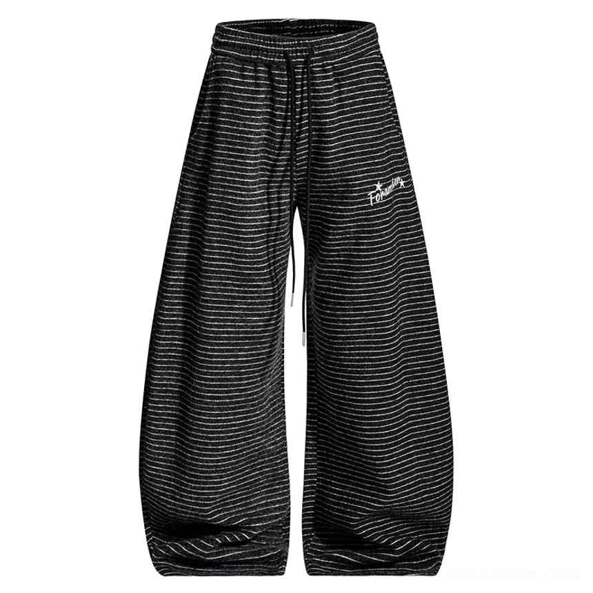 Flat lay of dark gray striped fleece wide-leg streetwear pants with thin horizontal stripes, elastic drawstring waist, and embroidered lettering