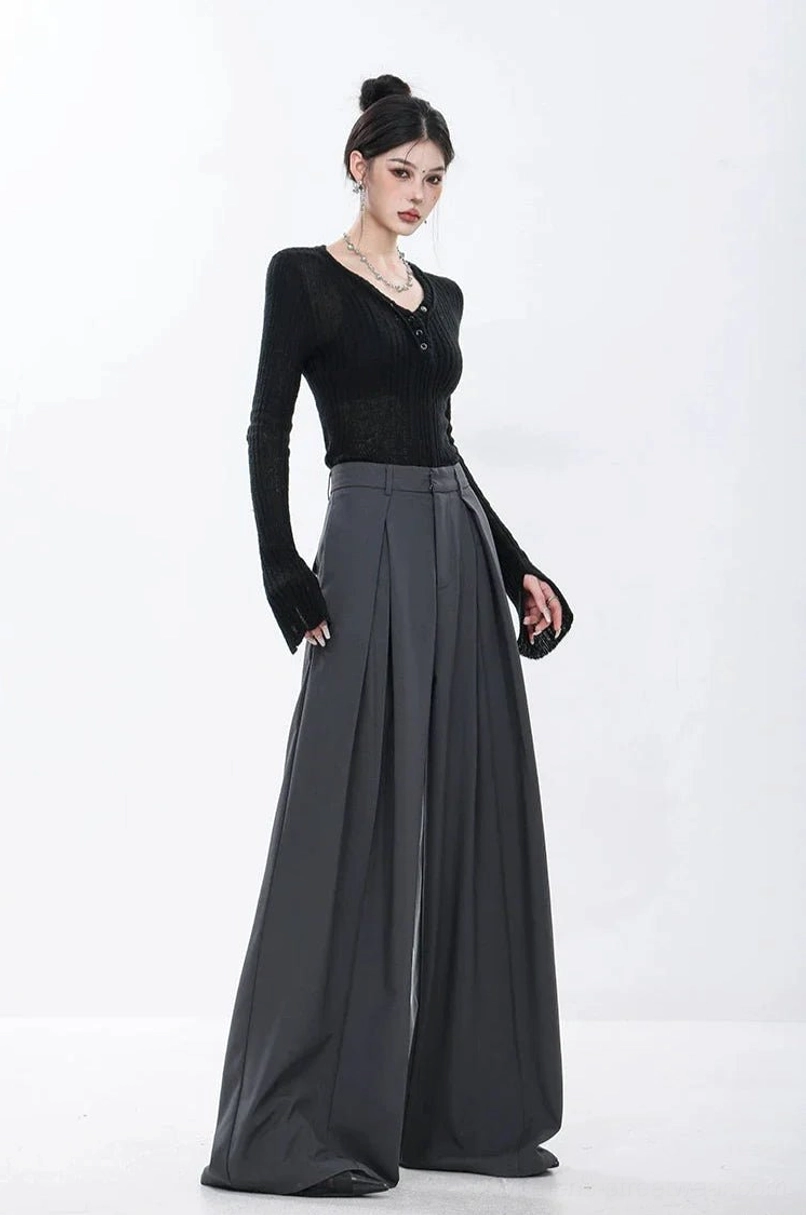 Dark gray tailored streetwear pants featuring deep front pleats and a long relaxed wide-leg shape