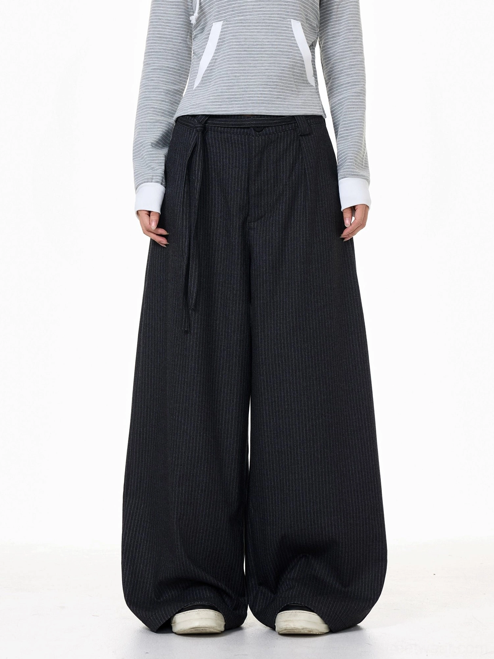 Dark gray wide-leg pinstripe streetwear pants with extended tie waist belt, belt loops, and relaxed oversized silhouette