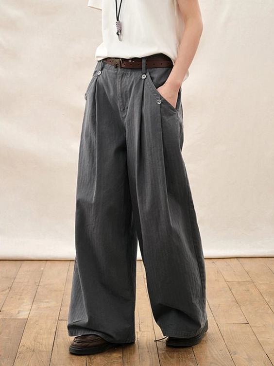 Dark gray wide leg pleated streetwear trousers close up showing belt loops waistband side pocket and front pleats