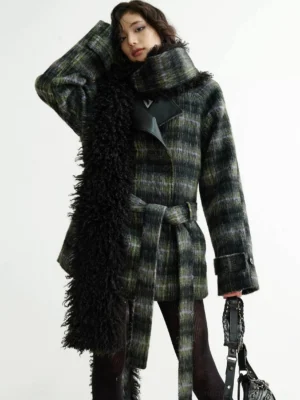 Front three-quarter view of a dark green plaid faux fur fringe wrap coat with oversized collar, leather-look lapels, black tights, and studded handbag